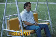 a man sits on a swing with a foreign language written on the bottom right