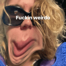 a woman wearing sunglasses makes a funny face with the words fuckin weirdo written above her