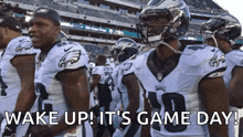 a group of eagles football players are standing in a stadium with the words wake up it 's game day