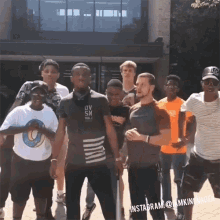 a group of young men standing in front of a building with one man wearing a shirt that says ov sn on it