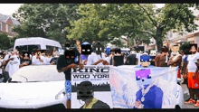 a group of people holding a banner that says king wod yori