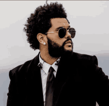 a man with an afro wearing sunglasses and a suit