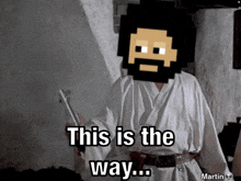 a man with a beard is holding a lightsaber and says " this is the way "