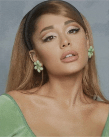 a close up of a woman 's face wearing a headband and earrings