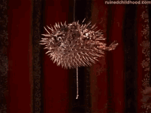 a person is holding a puffer fish shaped light fixture .