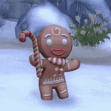 a gingerbread man is holding a candy cane in his hand while standing in the snow .