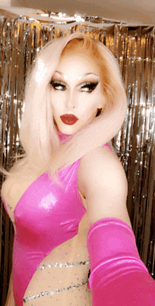 a woman in a pink bodysuit takes a selfie