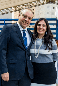 a man in a suit and tie poses with a woman