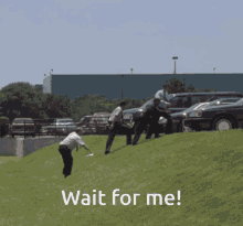 a group of people standing on top of a grass covered hill with the words wait for me below them