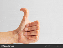 a woman 's hand giving a thumbs up on a white background