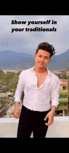 a young man wearing a white shirt and black pants is standing on a rooftop .