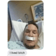 a man is laying in a hospital bed with a bandage on his mouth and a message that says i lived bitch