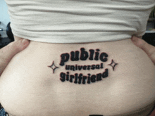 a woman has a tattoo that says public universal girlfriend