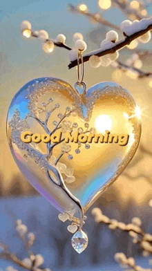 a heart shaped ornament hanging from a tree branch with the words `` good morning '' written on it .