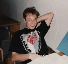 a young man wearing a black shirt that says justice drew on it