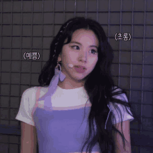 a woman wearing a white shirt and a purple top with korean writing on her face