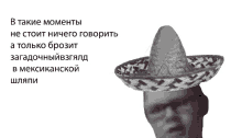 a man wearing a sombrero and glasses with a russian text behind him