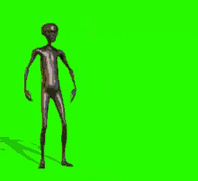 a naked alien is standing on a green screen .