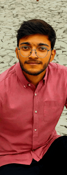 a man wearing glasses and a pink shirt