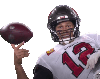 a man in a buccaneers jersey is holding a football in his hand