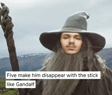 a man with a beard and a wizard hat is holding a cane and says five make him disappear with the stick