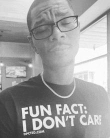 a man wearing glasses is wearing a shirt that says fun fact i don 't care