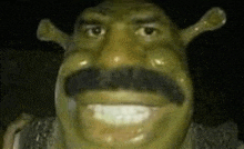 a close up of a shrek statue with a mustache and a hat .