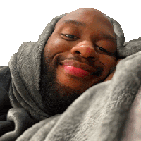 a man wrapped in a grey blanket is smiling