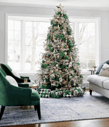 a living room decorated for christmas with a green and silver tree