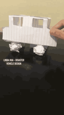 a person is holding a piece of paper with the words linda hua disaster vehicle design on it