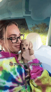 a woman in a tie dye sweatshirt is holding a small puppy and the caption says so you want a puppy