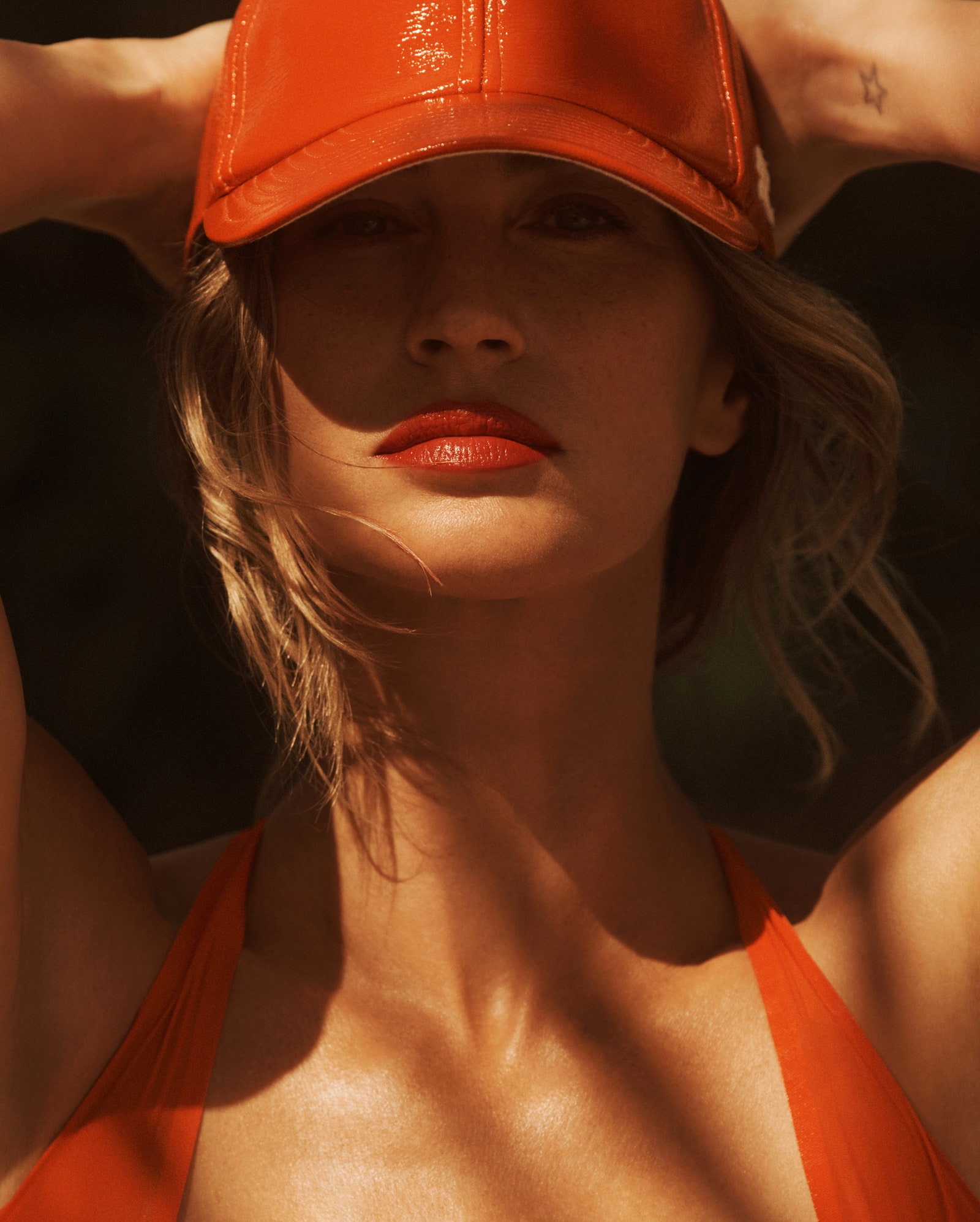 Gisele Bündchen is a red Alaïa bodysuit and Courrèges cap.