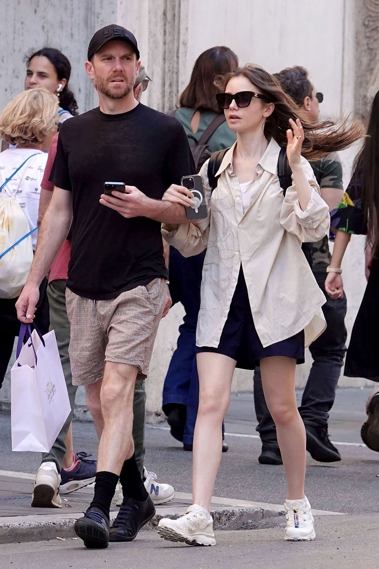 Image may contain Charlie McDowell Lily Collins Pedestrian Person Accessories Bag Handbag and Electronics