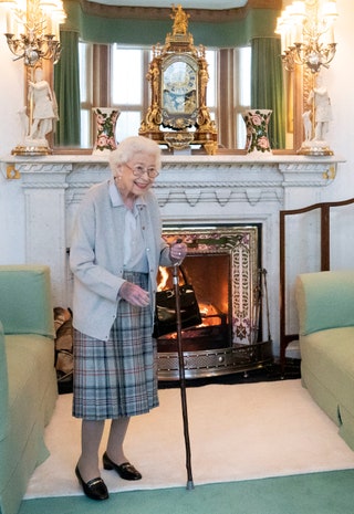 Image may contain Human Person Elizabeth II Hearth Indoors Fireplace Furniture and Cushion