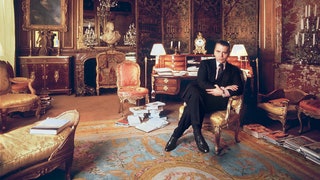 Karl Lagerfeld poses in front of a tiered bureau with amaranth and mahogany inlays at Hôtel Pozzo di Borgo attributed to...