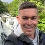 Michael Frost smiling and standing in front of a waterfall.