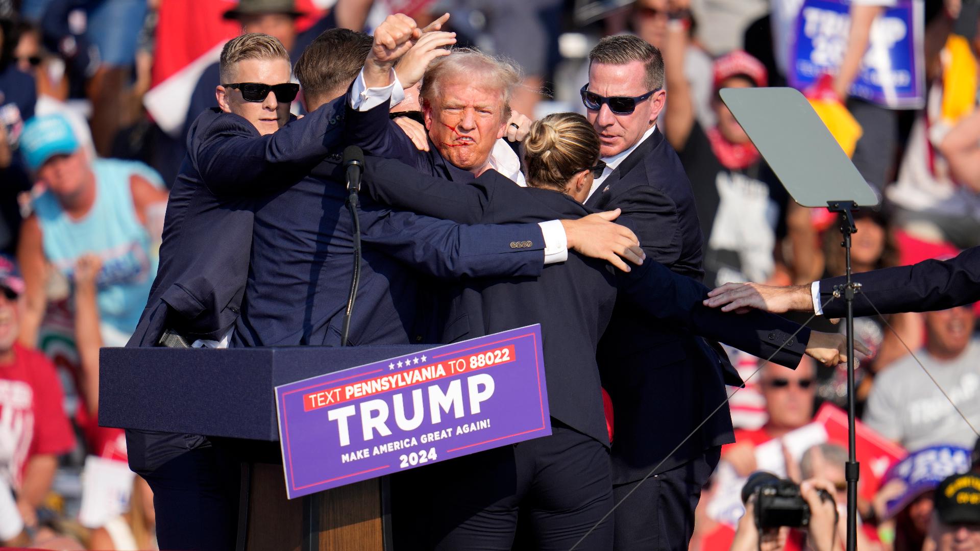 Someone is heard yelling, "Get down" as Trump takes cover.