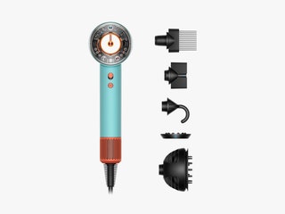 Handheld hair dryer with narrow handle and cylindrical main component beside detachable accessories such as a comb