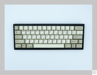 Computer keyboard with tan and beige keys and black trim all around