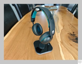 Black padded headphones hanging from silver stand