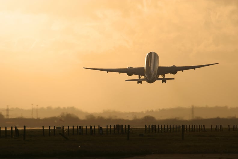 Commercial aircraft taking off in the sunset.