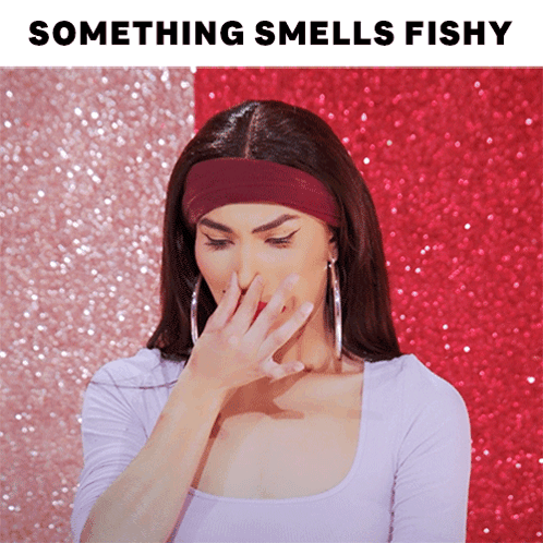 a woman covering her nose with her hand and the words something smells fishy behind her