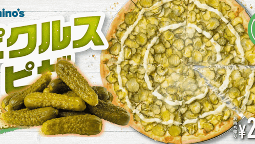 a domino 's pizza with pickles and a pile of pickles next to it