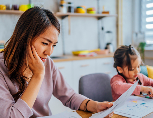 Women looking at financial papers next to her daughter