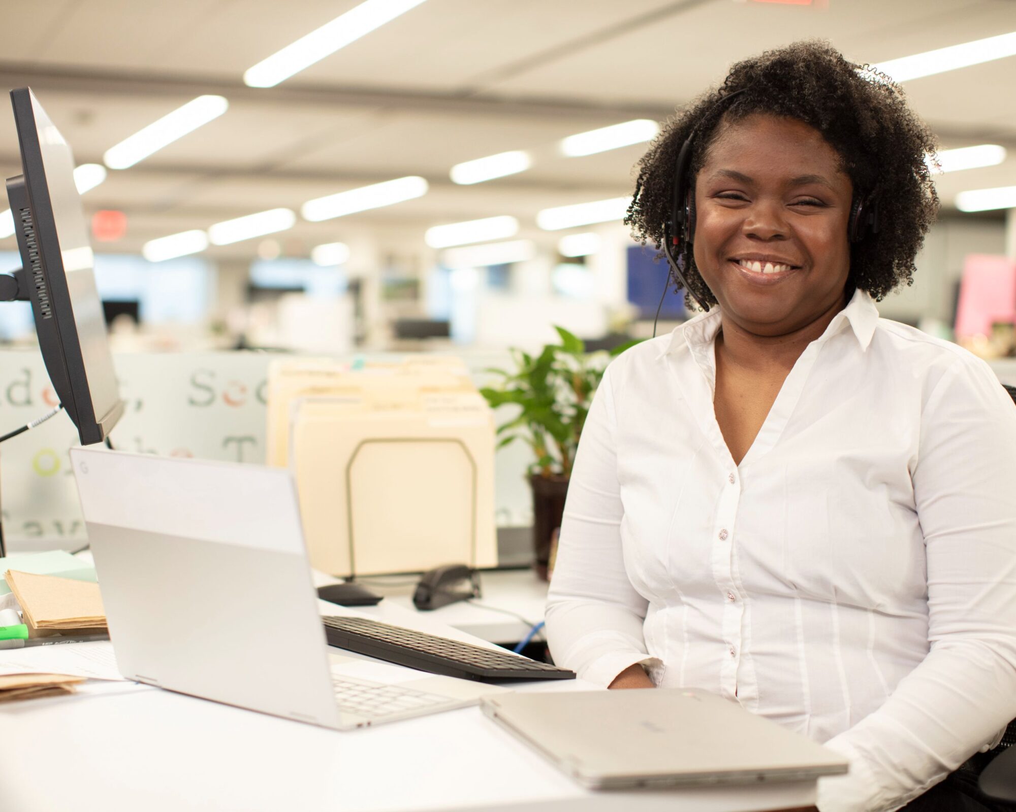 Tonya, an IT Support alumni, stands smiling at the camera.