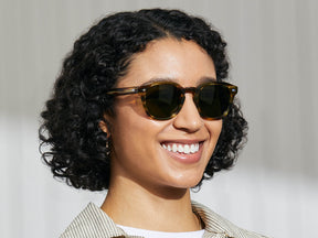 Model is wearing The LEMTOSH SUN in Bamboo in size 52 with Calibar Green Glass Lenses