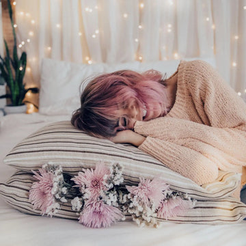 Woman with pink hair smiling on Essentia Comfort Pillows