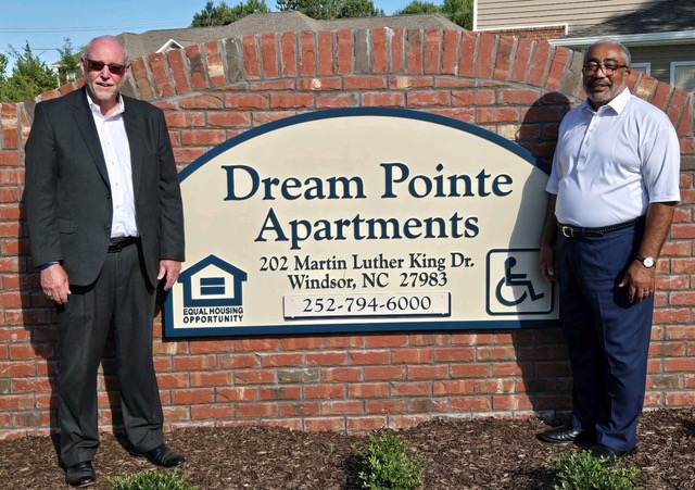 James Eure and Ron Wesson standing front of a sign reading "Dream Pointe Apartments"
