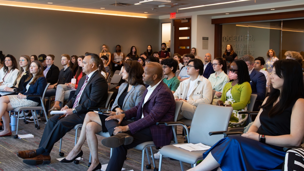 Room full of students, leaders and supporters listen at an event