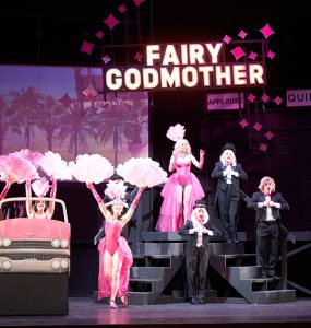 opera production with chorus girls and "fairy godmother' in neon lights